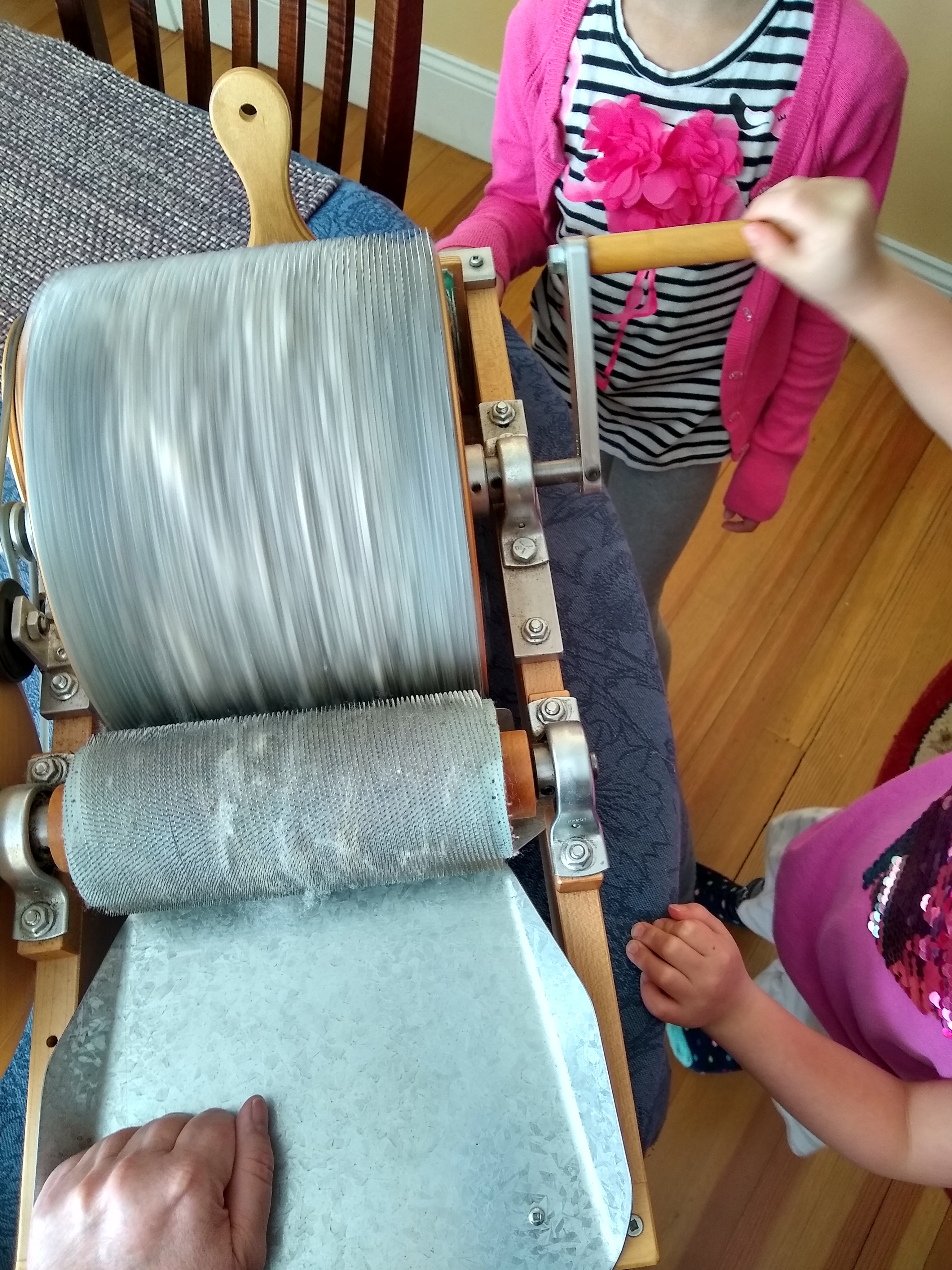 Children using a drum carder